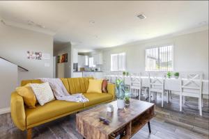 a living room with a yellow couch and a table at Cheerful 5BR house with parking near USC in Los Angeles +31 photos