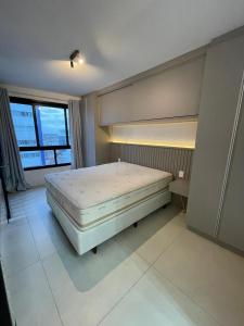 a bedroom with a bed and a large window at Vesta - melhor localização Torres in Torres