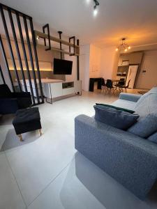 a living room with a blue couch and a tv at Vesta - melhor localização Torres in Torres