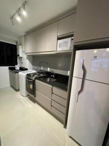 a kitchen with a stove and a refrigerator at Vesta - melhor localização Torres in Torres