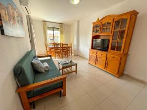 ein Wohnzimmer mit einem grünen Sofa und einem Tisch in der Unterkunft Apartamentos Entreplayas 3000 in Oropesa del Mar
