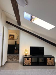 uma sala de estar com uma televisão e uma clarabóia em La Mansarda em Como