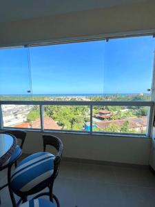 une chambre avec deux chaises et une grande fenêtre dans l'établissement Vista Mar Buraquinho, à Lauro de Freitas