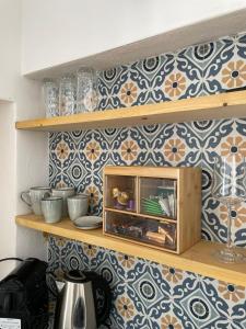 a kitchen shelf with bowls and plates on a blue and white tiles at Casa San Cayetano in Crevillente