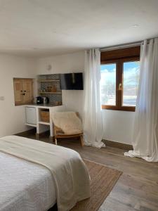 a bedroom with a bed and a kitchen with a window at Casa San Cayetano in Crevillente