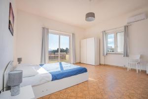 1 dormitorio con cama y ventana grande en Tramontana vista mare 300m dalla spiaggia en Golfo Aranci