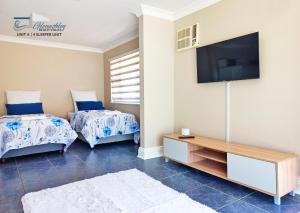 uma sala de estar com 2 camas e uma televisão de ecrã plano em Glen Ashley Beach Villas em Durban