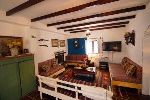 a living room with couches and a table and a tv at Cidrão dos Brejos in Santiago do Cacém