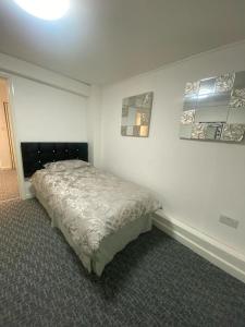 a bedroom with a bed in the corner of a room at Beautiful 3-Bed apartment in Merthyr Tydfil in Merthyr Tydfil