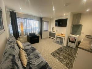 un ampio soggiorno con divano e cucina di Beautiful 3-Bed apartment in Merthyr Tydfil a Merthyr Tydfil