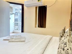 um quarto com uma cama branca e uma janela em Hotel Yashasvi inn ! Puri near-sea-beach-and-temple fully-air-conditioned-hotel with-lift-and-parking-facility breakfast-included em Puri