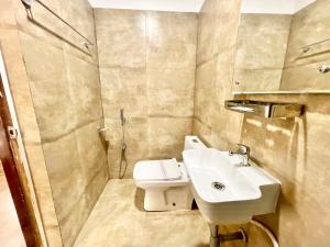 y baño con lavabo, ducha y aseo. en Hotel Yashasvi inn ! Puri near-sea-beach-and-temple fully-air-conditioned-hotel with-lift-and-parking-facility breakfast-included, en Puri