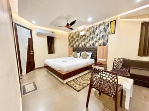 a bedroom with a bed and a chair and a couch at Hotel Yashasvi inn ! Puri near-sea-beach-and-temple fully-air-conditioned-hotel with-lift-and-parking-facility breakfast-included in Puri