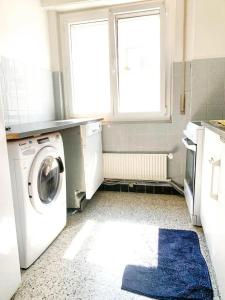 uma lavandaria com uma máquina de lavar roupa e uma janela em Chambre Privé em Vallorbe