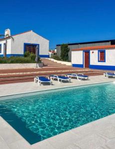 una piscina con sillas y una casa en Monte das Flores, 