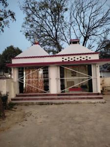 uma pequena casa com uma cerca em frente em Mahadev Retreat em Faizābād