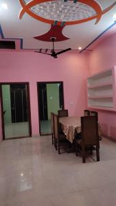 uma sala de jantar com uma mesa e cadeiras e paredes cor-de-rosa em Mahadev Retreat em Faizābād