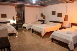 een kamer met vier bedden in een kamer bij Hotel Karlaká Calarcá Quindio in Calarcá