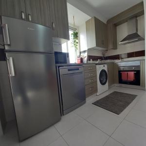 uma cozinha com um frigorífico de aço inoxidável e uma máquina de lavar louça em Friendly Peniche Apartment em Peniche