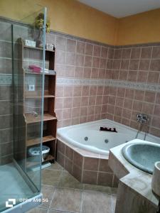 Das Bad ist mit einer Badewanne und einer Glasdusche ausgestattet. in der Unterkunft Habitación en chalet, ambiente tranquilo in El Puerto de Santa María