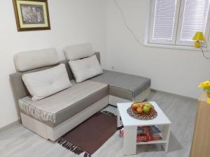 a couch in a living room with a table at Apartman Plaza 9 in Veliko Gradište
