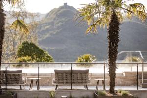 eine Gruppe Stühle und einen Tisch mit einer Palme in der Unterkunft Lake Spa Hotel SEELEITEN in Kaltern