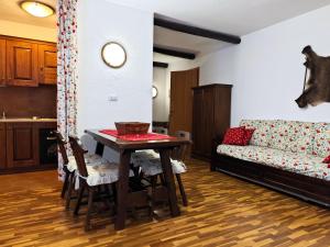 a living room with a table and a couch at Hostdomus - Wood Apartment in Cesana Torinese