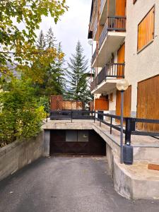 a parking lot next to a building with a garage at Hostdomus - Wood Apartment in Cesana Torinese