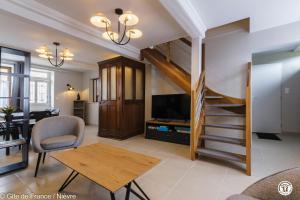 a living room with a staircase leading up to a loft at Le gîte de la poste in Onlay