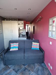 Una sala de estar con un sofá y una cocina. en Le Boudha Love, en Cap d'Agde