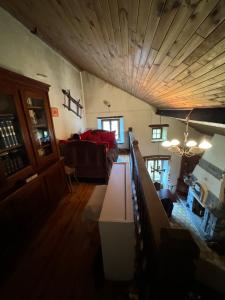 - un salon avec un canapé et un plafond en bois dans l'établissement Maison auvergnate, à Dauzat-sur-Vodable