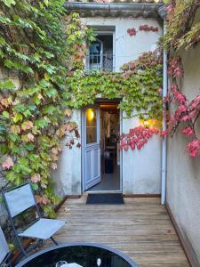 una entrada a una casa con hiedra en la pared en Le Gite de la Galerie Forge en Alaigne