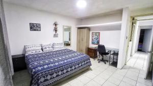 1 dormitorio con cama, escritorio y silla en Dpto 1er Nivel Punta hermosa 3hab, wifi, tv, parrilla, en Punta Hermosa