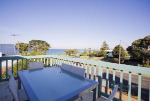 a blue table and chairs on a balcony with the ocean at Torquay Retreats - Anderson in Torquay