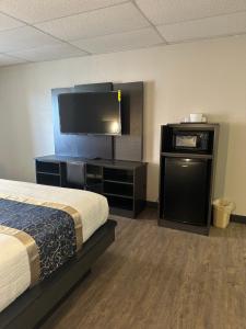 a hotel room with a bed and a flat screen tv at Baymont by Wyndham Deming in Deming