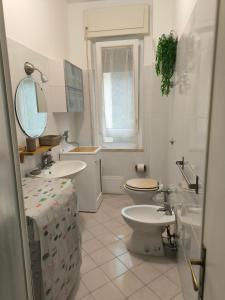 bagno con servizi igienici, lavandino e specchio di TamarHouse Sperlonga Casa Naila a Sperlonga