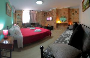 a bedroom with a red bed and a couch at Ionia rooms in Chios