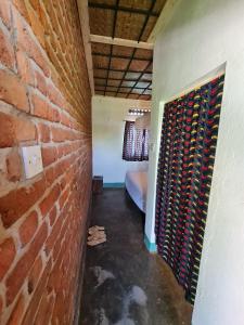 a hallway with a brick wall and a bed in a room at Rwekishokye Country Club in Mbarara +10 photos
