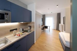 a kitchen with blue cabinets and a sink in a room at Brera Serviced Apartments Singen in Singen