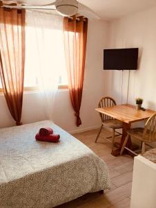 a bedroom with a bed and a table and a television at My home in Saint-Tropez