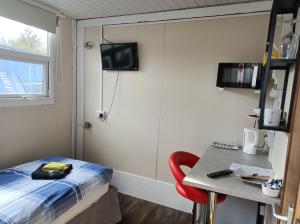 a room with a bed and a table and a window at The Townhouse Self Catering in Dumfries