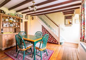 a dining room with a green table and chairs at Rose Cottage in Richmond