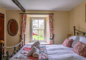 a bedroom with a bed with two dolls on it at Rose Cottage in Richmond