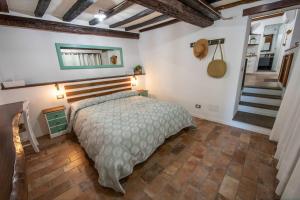sypialnia z łóżkiem w pokoju ze schodami w obiekcie Vicolo39 La casa a due passi dal Lago w mieście Trevignano Romano