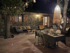 un patio avec une table, des chaises et un canapé dans l'établissement Villa Bergerie Baracco Argia, piscine, maquis et tradition corse pour 6 personnes, à Barbaggio