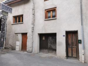 een wit gebouw met vier deuren aan de zijkant bij Coquet T1 hyper centre in Le Bourg-dʼOisans