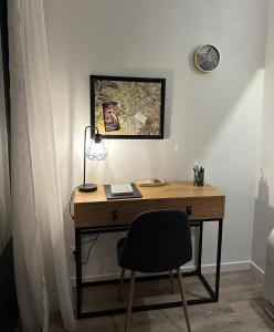 un bureau avec une chaise et un réveil sur un mur dans l'établissement VILLA GABI, à Juvisy-sur-Orge