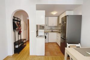 a kitchen with white cabinets and a refrigerator at Balcón hacia la montaña in Güéjar-Sierra +3 photos