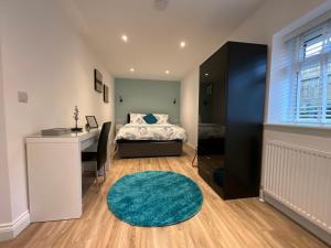 a bedroom with a bed and a desk and a rug at The Court Yard Apartment in Cheddar