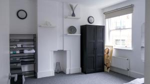 ロンドンにあるModern Apartment in Shoreditch, City Centreのベッドルーム1室(黒いキャビネット、窓付)